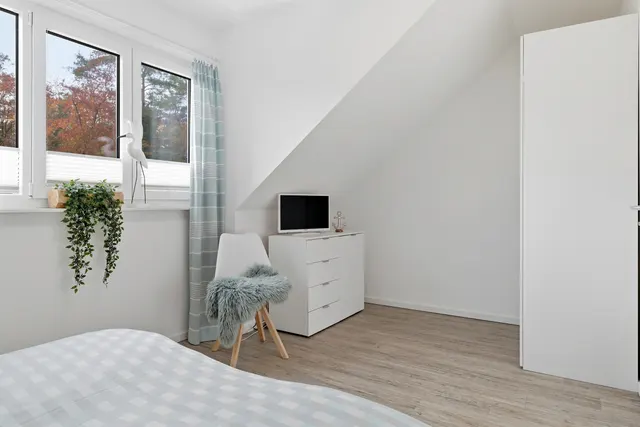 Schlafzimmer mit Kommode und Fernseher