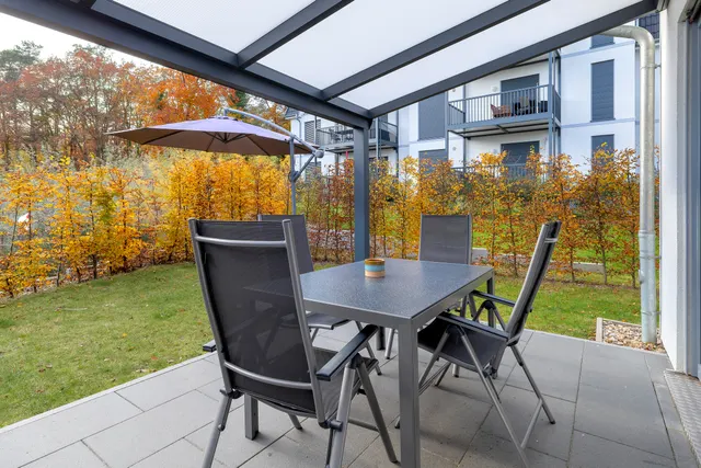 Terrasse mit Tisch und Stühlen im Herbstlicht